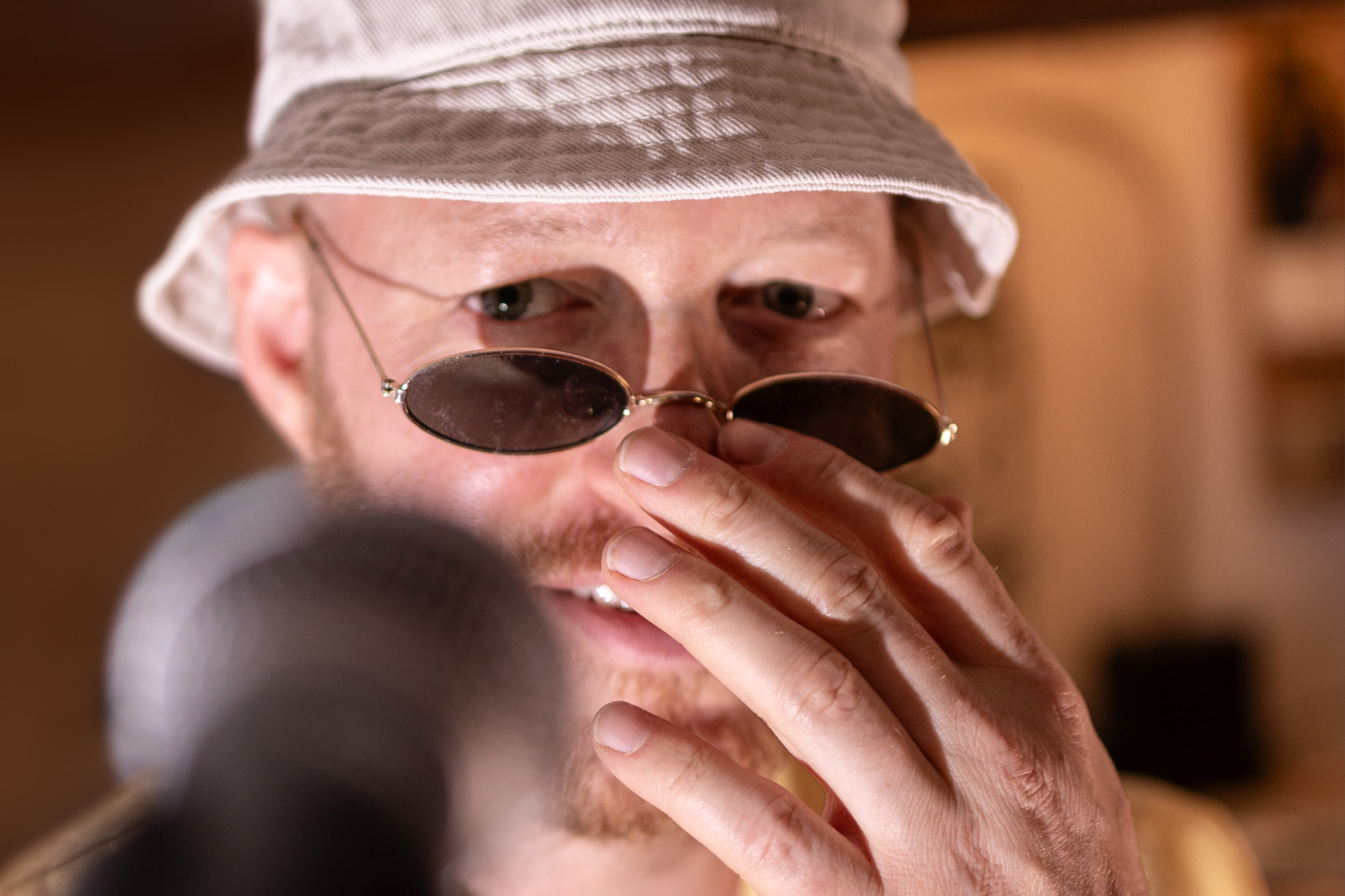 Nahes Porträt von Future Franz mit Hut und Sonnenbrille hinter einem unscharfen Mikrofon.